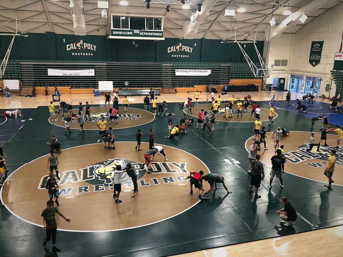 Campers drilling across every mat during a camp session in a Cal Poly gym